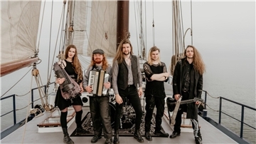 Musiker stehen auf einem Segelboot.