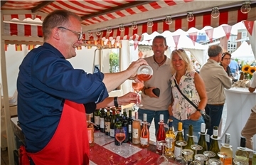 Tropfenreiche Tage auf dem Theodor-Heuss-Platz: Von oben etwas Regen und in der Hand den Edlen- so lässt es sich beim Weinfest aushalten. Burghard Stamer von Jacques´ Weindepot schenkt ein.
