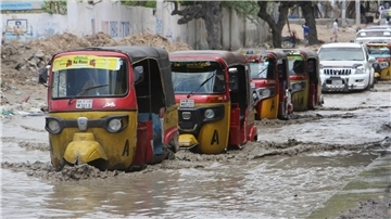 Tuktuks fahren durch eine überflutete Straße nach starkem Regen in Mogadischu.
