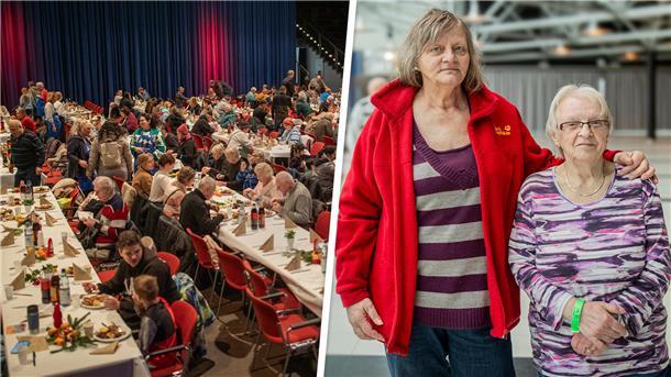 Mehrere Tischreihen mit Menschen. Und ein Bild von zwei Frauen. 