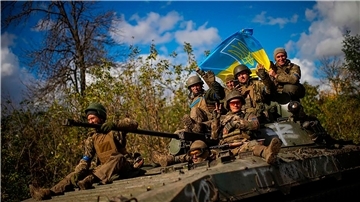 Ukrainische Soldaten fahren eine Straße zwischen Isjum und Lyman entlang.