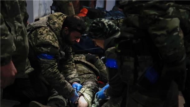 Ukrainische Soldaten leisten einem verwundeten Soldaten in einem Unterschlupf in Soldedar Erste Hilfe.