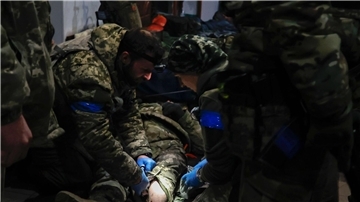 Ukrainische Soldaten leisten einem verwundeten Soldaten in einem Unterschlupf in Soldedar Erste Hilfe.