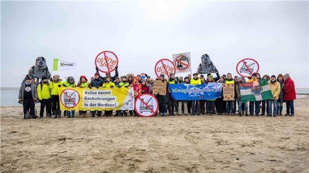 Umweltschützer und Insulaner demonstrieren am Weststrand von Borkum mit Bannern und Plakaten gegen die geplante Erdgasförderung.
