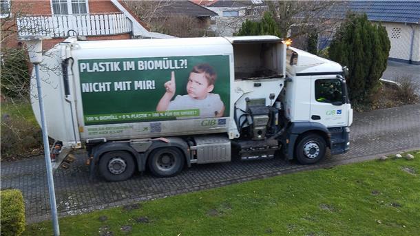 Ein Müllwagen steht vor einem Haus.