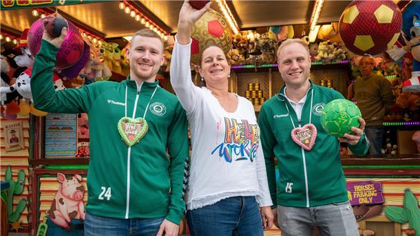 Ungewöhnlicher Wettstreit auf dem Freimarkt: Sonja Freese oder Marco von Bassen (links) mit Lucien Olsowski vom TV Schiffdorf - wer hat den besseren Wurf auf die Dosen?