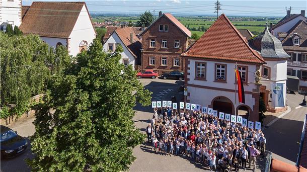 Eine Gruppe von Menschen hält Buchstaben hoch.