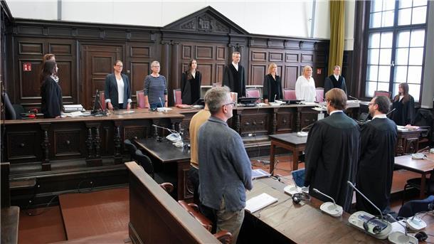 Prozess gegen möglichen Kokainschmuggler hat begonnen Unter anderem der Angeklagte, verdeckt im bräunlichen Shirt, hat sich erhoben.