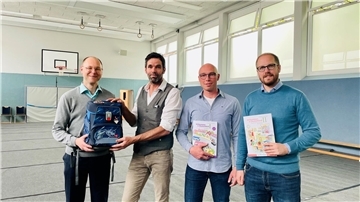 Unterstützung für die Grundschulen in Wilstedt und Tarmstedt: Die Pastoren Benjamin Fromm (links) und Christoffer Klemme (rechts) überreichen symbolisch Ranzen und Arbeitshefte an Dirk Meyer (Grundschulkonrektor in Tarmstedt) und Jan Holsten.