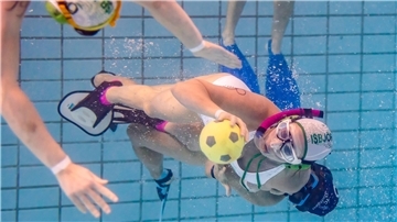 Frauen kämpfen beim Unterwasserrugby um den Ball.