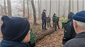 Uwe Lilienthal auf einem Baumstamm bei der Holzauktion in Holßel