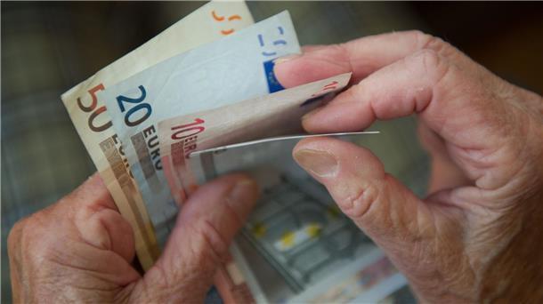 Hände einer älteren Person haben Geldscheine in der Hand.
