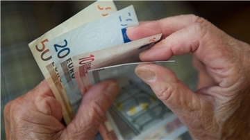 Hände einer älteren Person haben Geldscheine in der Hand.