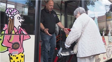 VBN Mitarbeiter André Gieschen zeigt Monika Zimmering, wie sie mit ihrem Rollator sicher in den Bus einsteigen kann.