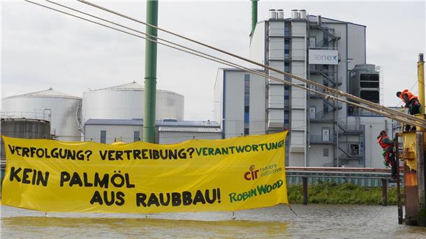 Auf dem Foto ist ein Banner zu sehen, das Umweltaktivisten vor der Fettraffinerie in Brake aufgehängt haben.