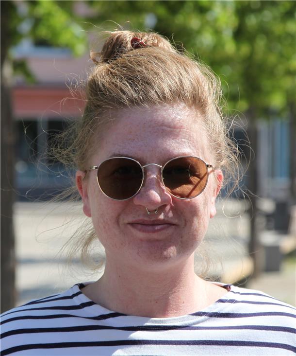 Eine Frau mit Sonnenbrille und gestreiftem T-Shirt.