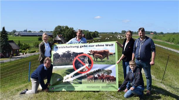 Vertreter des Landvolkverbands, der Landfrauen und der Deichschäferfamilie Bockelmann/de Jong mit dem Anti-Wolf-Plakat, das nun vielerorts in der Wesermarsch zu sehen ist.