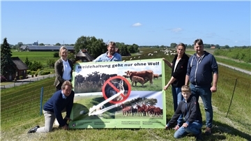 Vertreter des Landvolkverbands, der Landfrauen und der Deichschäferfamilie Bockelmann/de Jong mit dem Anti-Wolf-Plakat, das nun vielerorts in der Wesermarsch zu sehen ist.