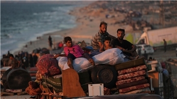 Vertriebene Palästinenser fliehen aus Gaza und tragen ihre Habseligkeiten entlang der Küstenstraße in Richtung des südlichen Gazastreifens.