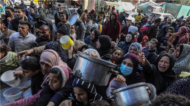 Vertriebene Palästinenser warten in Rafah, im Süden des Gazastreifens, auf Lebensmittel, die von palästinensischen Freiwilligen verteilt werden.