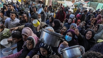 Vertriebene Palästinenser warten in Rafah, im Süden des Gazastreifens, auf Lebensmittel, die von palästinensischen Freiwilligen verteilt werden.
