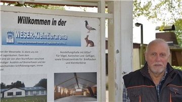 Siegfried Richter steht vor dem Willkommen-Schild der Kleintierarena.