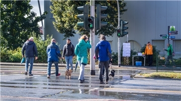 Passanten überqueren einen Straße.