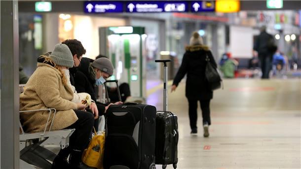 Bahnreisende warten am Hauptbahnhof auf einen Zug. 