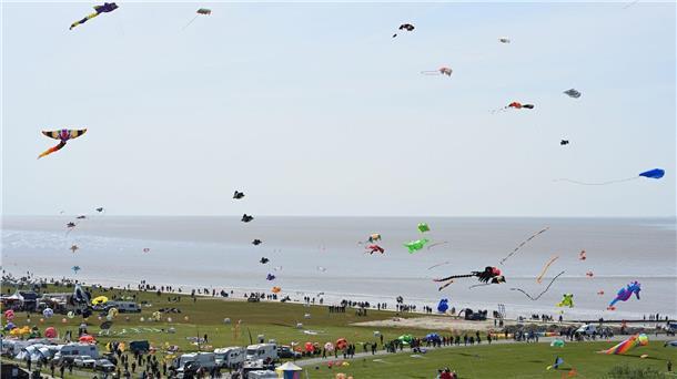 Viele bunte Drachen wehen über dem Strand von Norddeich.