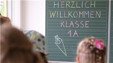  „Herzlich willkommen Klasse1 A“ steht an der Tafel eines Klassenzimmers