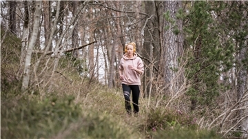 Eine Frau joggt durch den Wald.