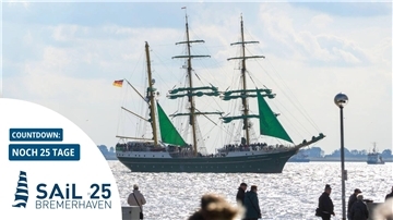 Das Schiff Alexander von Humboldt 2 bei einer Fahrt über die Weser. Menschen stehen am Deich und gucken zu.