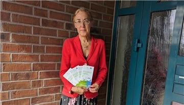 Eine Frau hält Broschüren in der Hand.