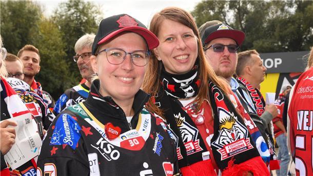 Zwei Frauen in der Fan-Kluft der Fischtown Pinguins lächeln vor dem Spiel der Bremerhavener Eishockeymannschaft gegen denMeister Eisbären Berlin in die Kamera.