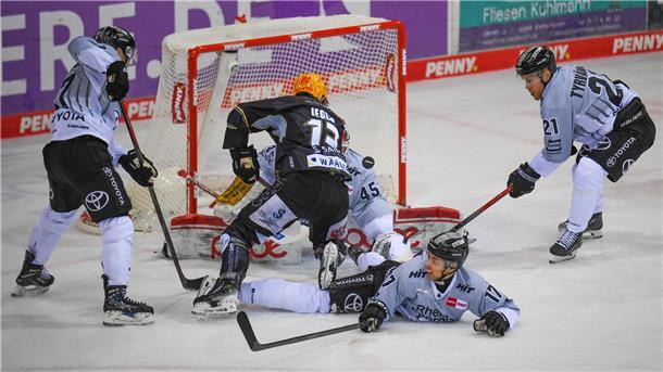Eishockeyspieler im Zweikampf vor dem Tor.