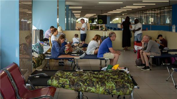 Brände auf Rhodos: Wind erschwert Löscharbeiten Von den Waldbränden betroffene Touristen warten am internationalen Flughafen Diagoras auf ihren Flug.