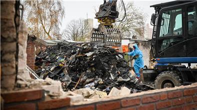 Ruine, Bagger, Arbeiter im Schutzanzug.