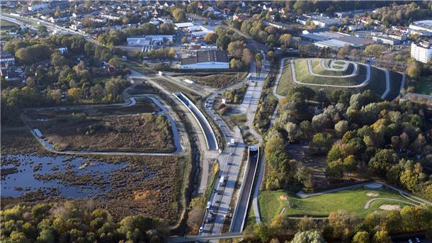 Von der Autobahn kommend steuert der Verkehr auf das östliche Tunnelportal zu. Rechts ist der Leherheider Tunnelberg gut zu erkennen.