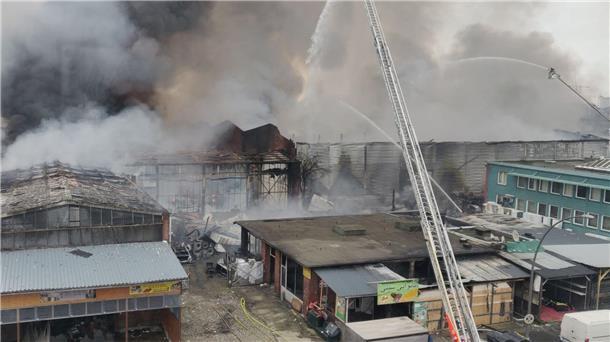 Hamburg im Rauch nach Großbrand Von einer Drehleiter aus spritzen Feuerwehrleute Wasser auf brennende und stark rauchende Lagerhallen.