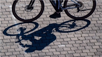 Schatten eines Fahrradfahrers auf Pflastersteinen