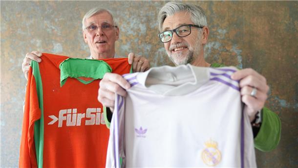 Zwei Männer halten Trikots von SFL Bremerhaven und Real Madrid.