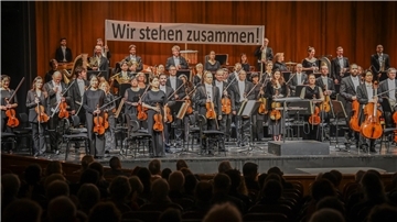 Vor dem 3. Sinfoniekonzert am Montag und Dienstag demonstrierten die Orchestermitglieder mit einem Banner ihre Geschlossenheit im Konflikt. Dafür gab es viel Beifall vom Publikum.