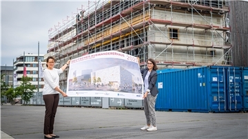 Vor dem Erweiterungsbau des Deutschen Auswandererhauses zeigen Direktorin Dr. Simone Eick (links) und die wissenschaftliche Mitarbeiterin für die Erweiterung des Hauses, Lina Falivena, wie es später aussehen soll.