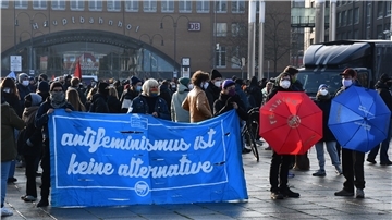 Demonstranten mit einem Plakat vor dem Bremer Hauptbahnhof.
