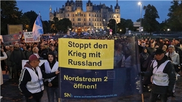 Vor dem Schweriner Schloss treffen sich Teilnehmer einer Demonstration, die gegen die Energiepolitik protestieren.