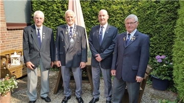 Delegation der Kameradschaft ehemaliger Soldaten Drangstedt nimmt für das Foto Aufstellung im Garten vor einer Hecke