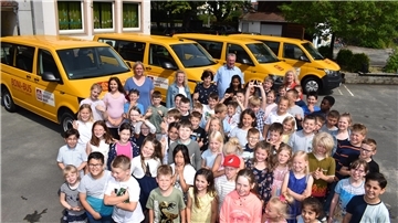 Die Kinder der Willehad-Schule vor den vier Boni-Bussen der Gemeinde.