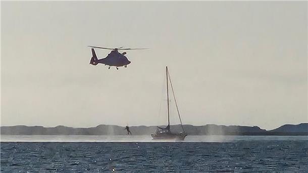 Vor der Insel Spiekeroog bringt ein Hubschrauber einen Sanitäter an Bord eines Segelboots.