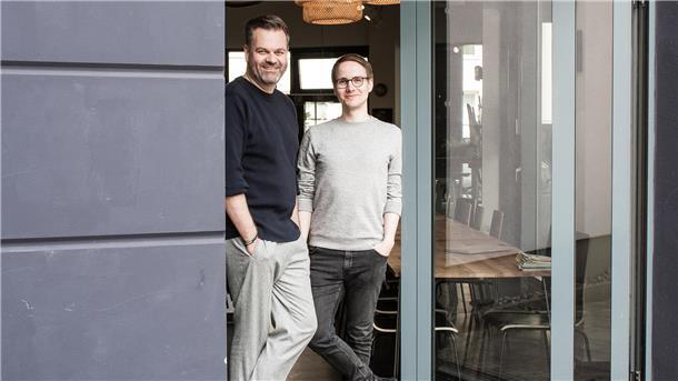 Zwei Männer posieren für ein Foto in einer Tür