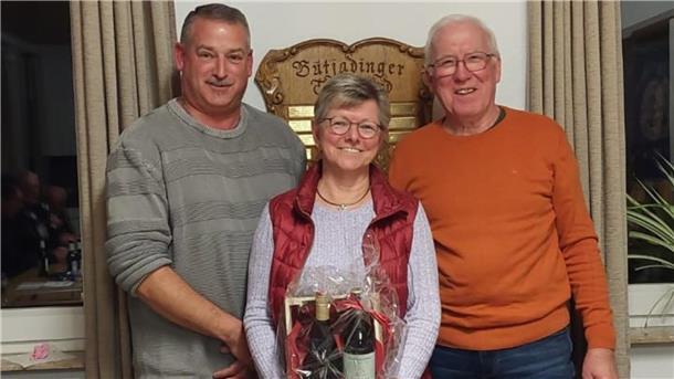 Zwei Männer und eine Frau mit einem Präsent. 